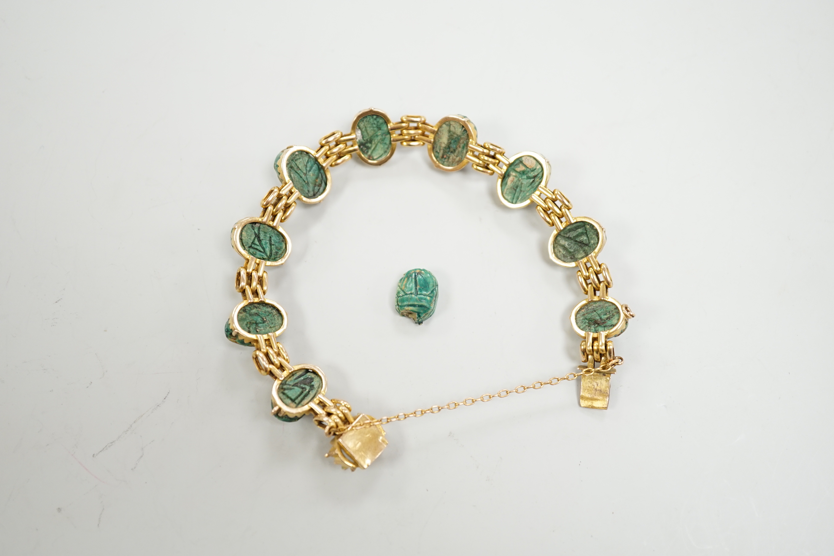 An early 20th century 9ct and ten stone ceramic scarab set bracelet (one stone loose), approx. 17cm, gross weight 20.3 grams.